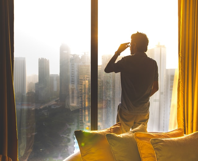 Picture of man looking out of window while working from home