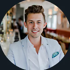 A smiling man in a light blue blazer